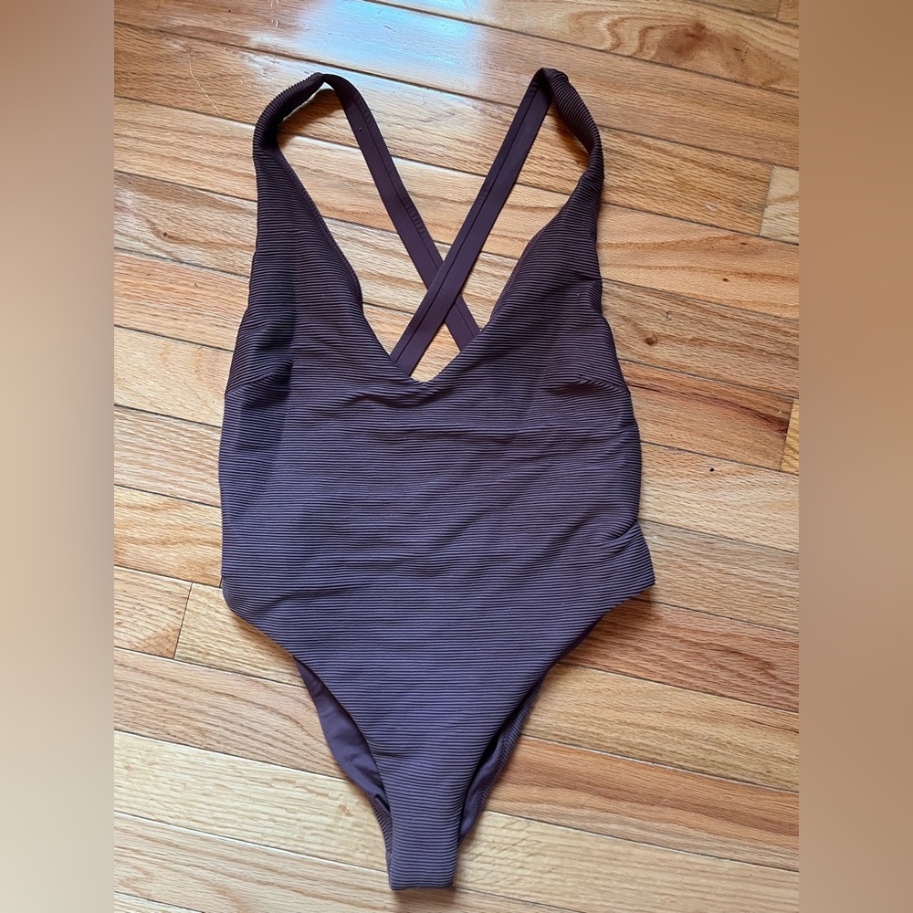 Small one piece high thigh bathing suit. Low cut v. Sexy. Cheeky